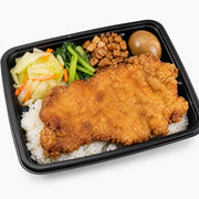 香酥大排便当盒，包含一大块金黄酥脆的炸大排、白米饭、卤蛋、青菜和炒卷心菜，采用黑色长方形便当盒盛装。