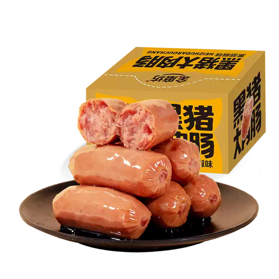 金磨坊黑猪大肉肠黑胡椒味包装盒与黑色圆盘上堆叠的即食香肠。