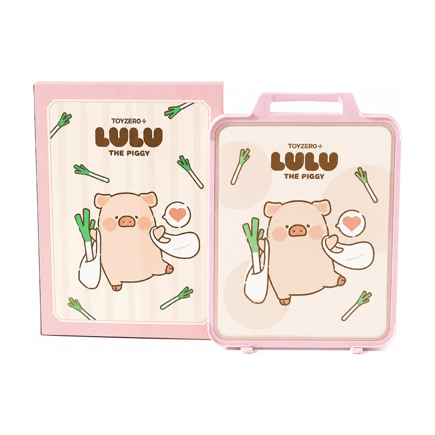 白色背景下的Lulu猪粉色抗菌菜板及其包装盒，菜板带有提手设计，中心印有可爱的Lulu猪手拿大葱的卡通图案。