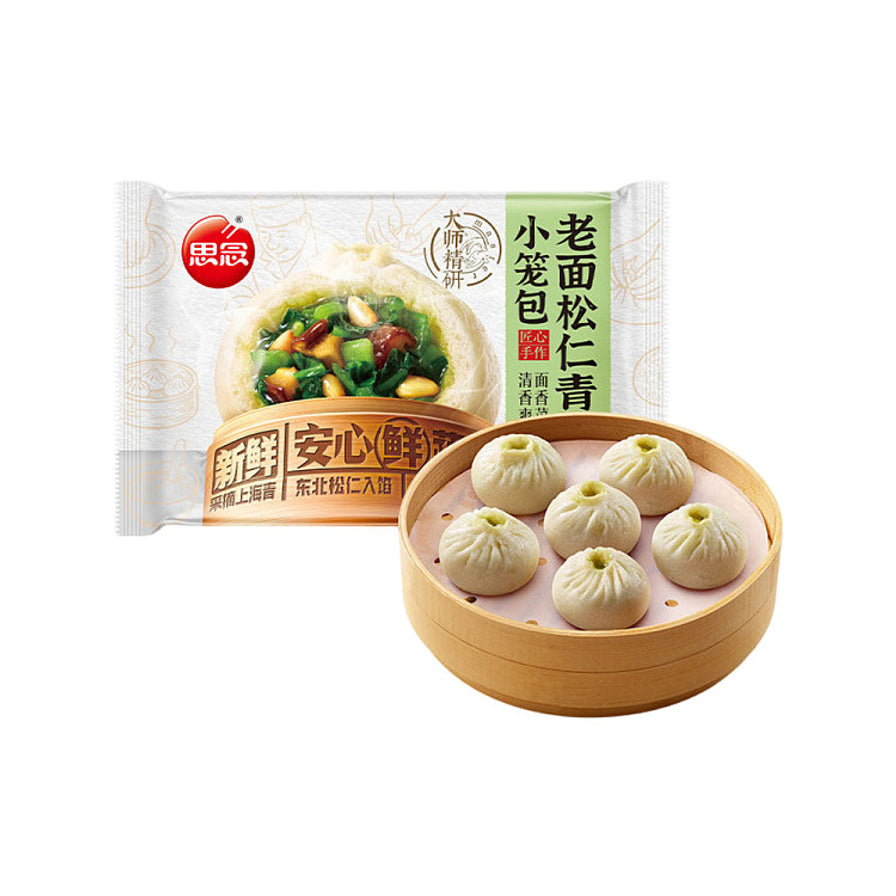 思念大师精研系列老面松仁青菜小笼包，前景为木制蒸笼里的六个小笼包，背景为产品包装袋。