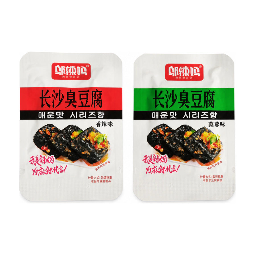 白色背景上并排展示的两包邬辣妈长沙臭豆腐，左侧为红色包装的香辣味，右侧为绿色包装的蒜蓉味，包装上印有诱人的黑色臭豆腐实物图。