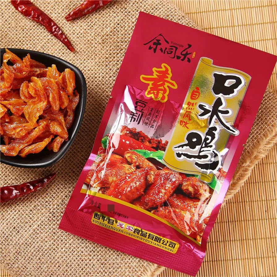 余同乐素食口水鸡味包装袋与黑色小碟中的香辣豆制品零食