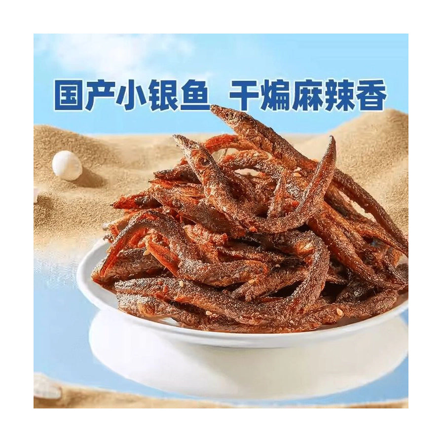 一盘堆叠整齐的干煸小银鱼，色泽红亮，上方配有“国产小银鱼 干煸麻辣香”的蓝色文字。