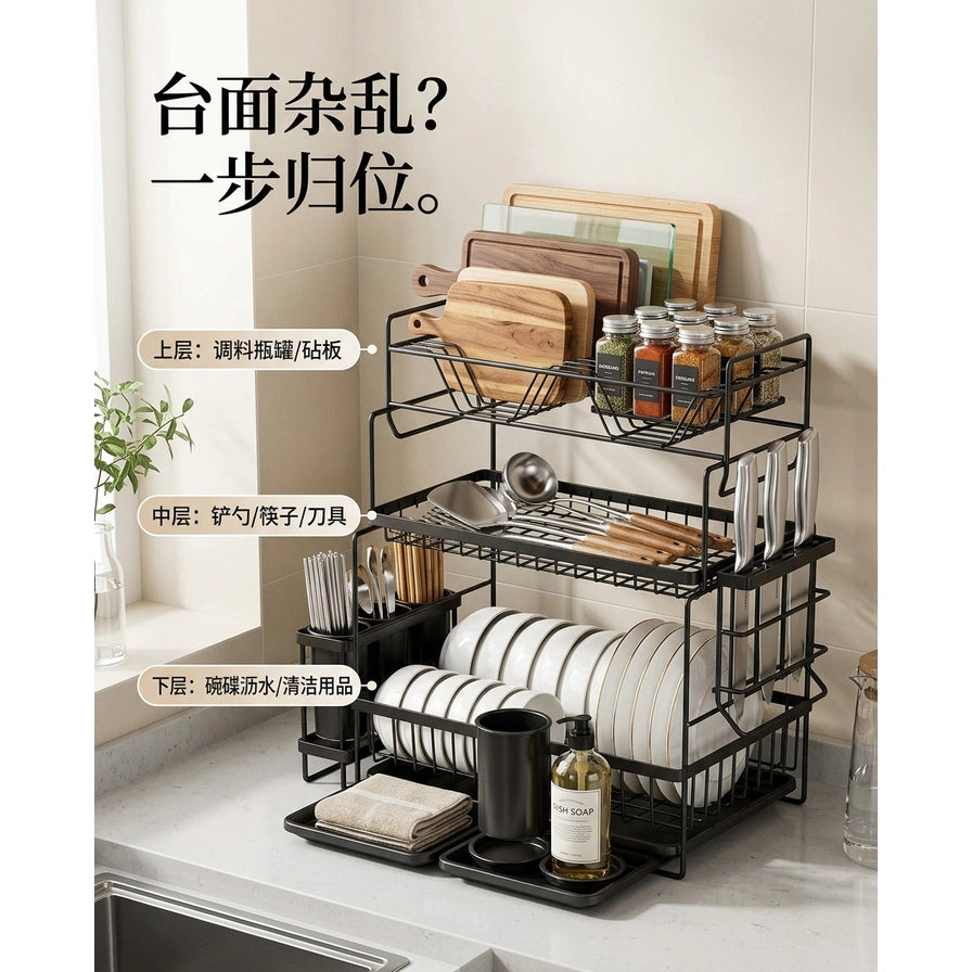 厨房台面上的黑色置物架收纳场景，配有中文文字说明各层用途：上层放调料瓶罐砧板，中层放铲勺筷子刀具，下层放碗碟沥水清洁用品。